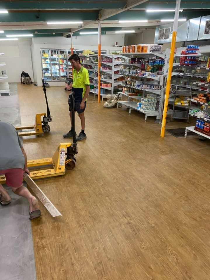 Workers in a Store With Pallet Jacks Installing Flooring — Ozwide Flooring In Ciccone, NT