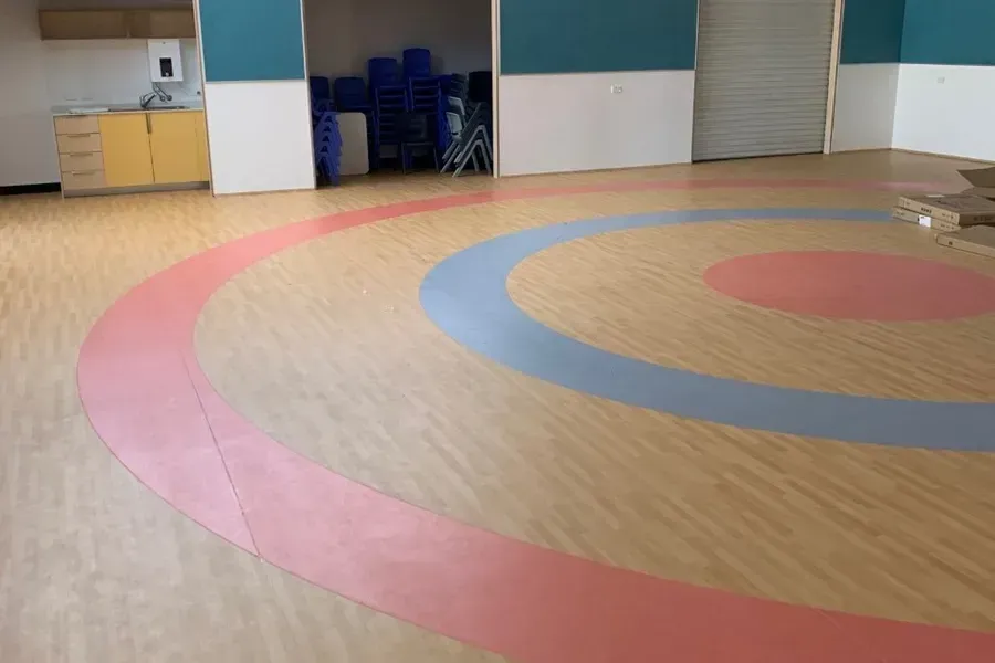 Wooden Floor With Concentric Circles in Pink and Blue, Inside a Large Room — Ozwide Flooring In Ciccone, NT