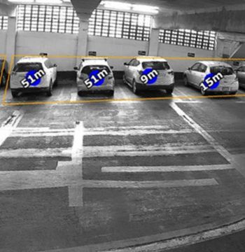 A black and white photo of a parking garage with cars labeled 51m 9m and 15m