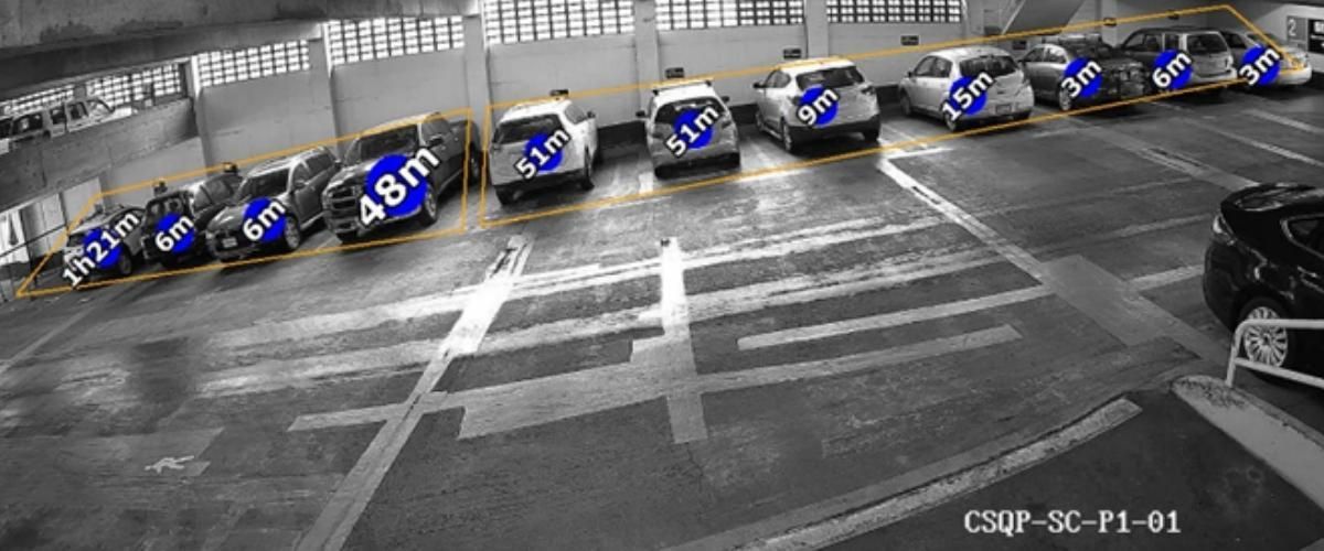 A row of cars are parked in a parking garage.