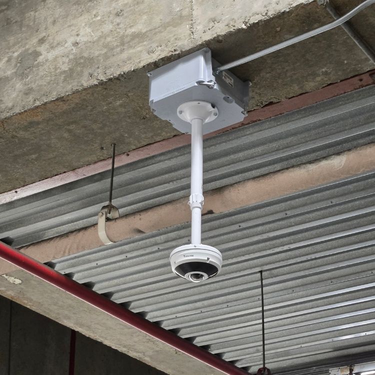 A camera is hanging from the ceiling of a building