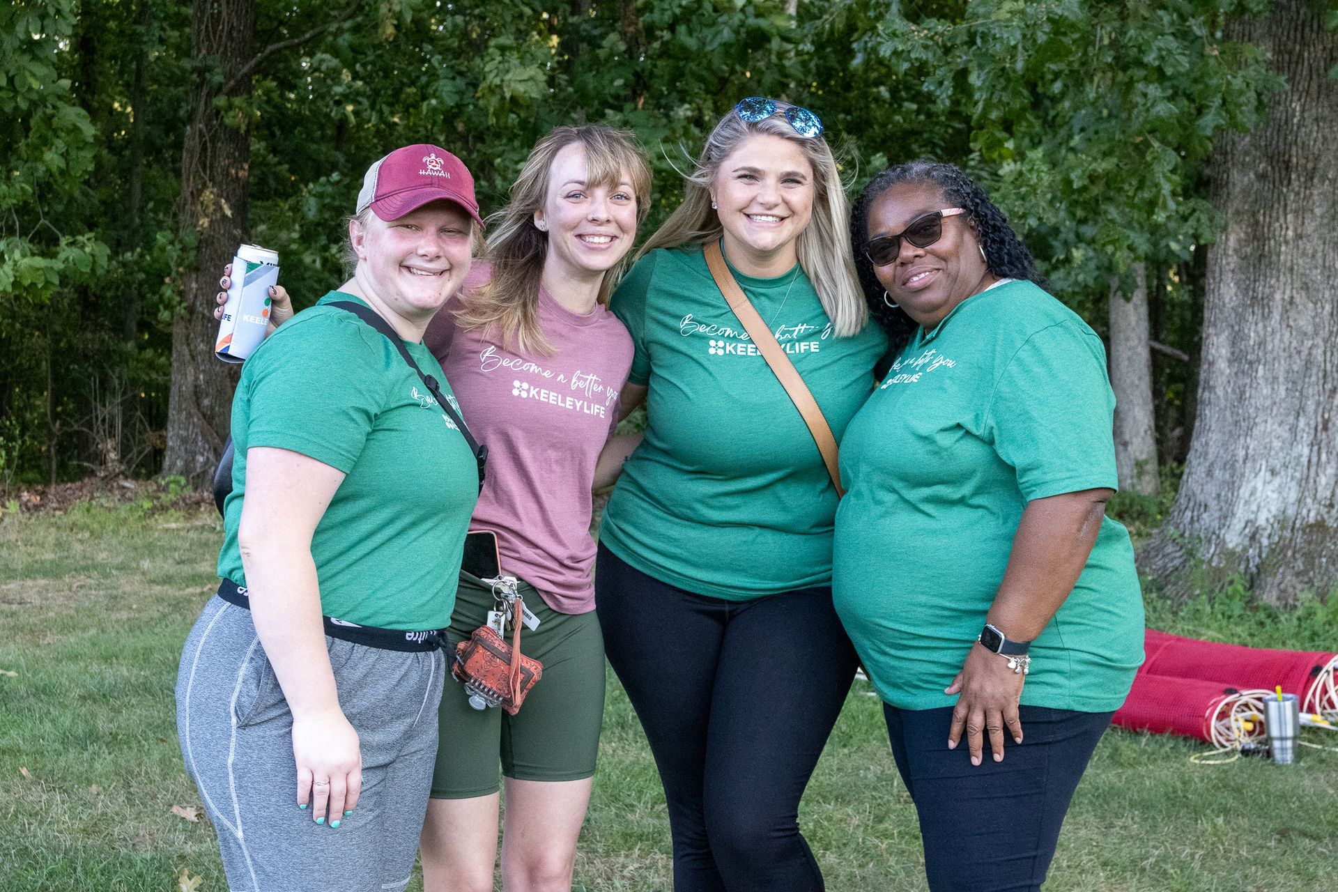 A group of women in green shirts are posing for a picture.