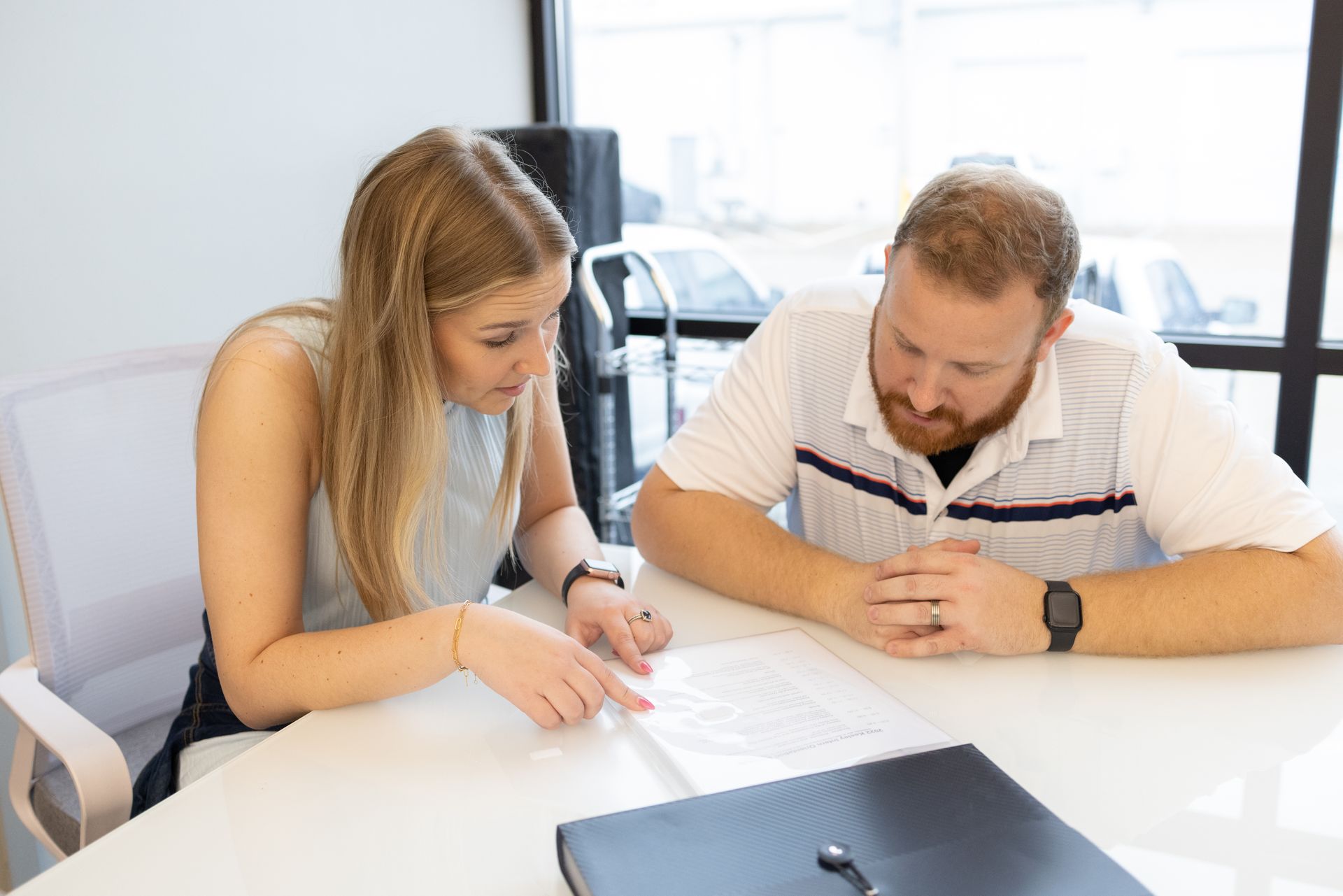 A man and a woman are sitting at a table looking at a piece of paper.