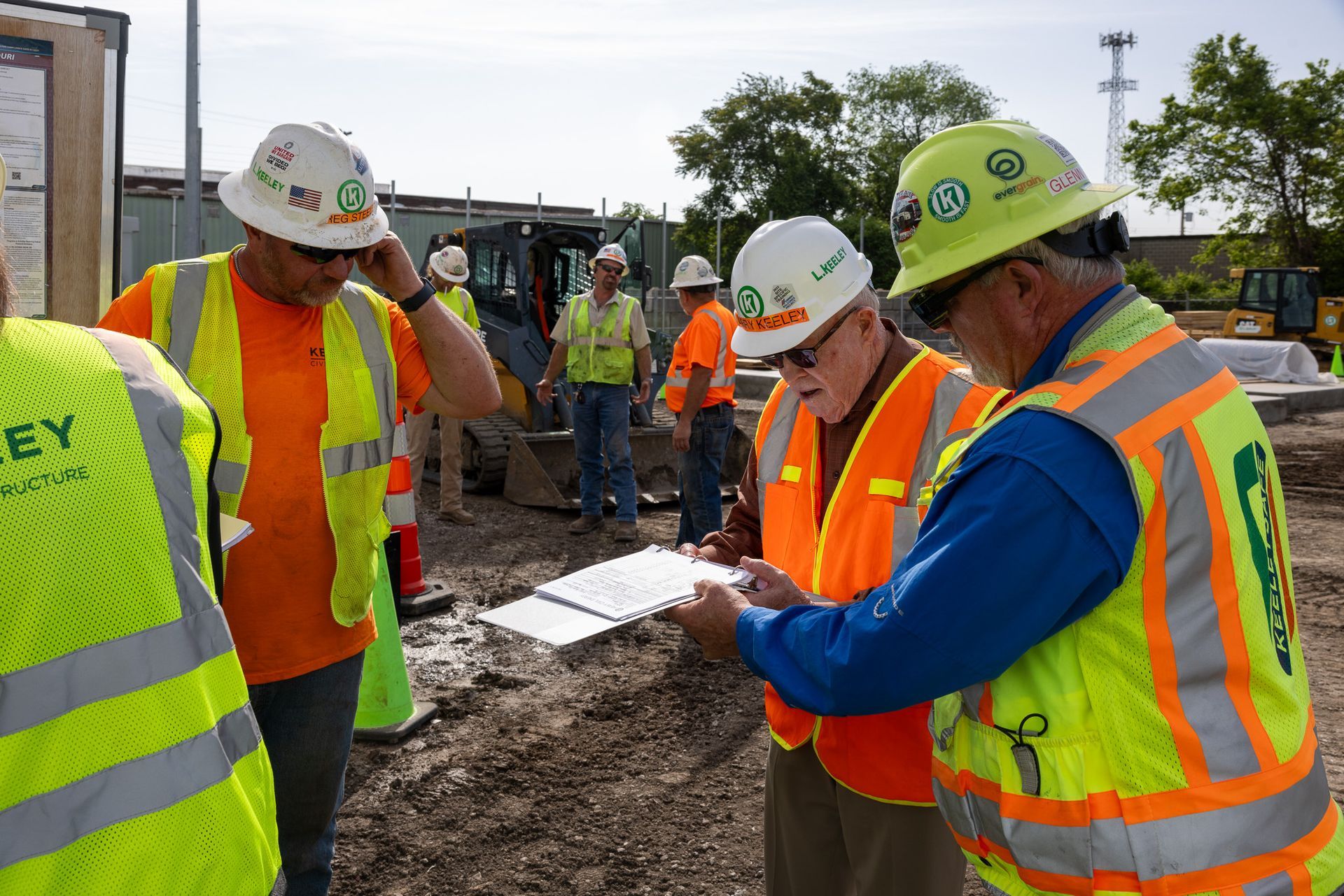 A group of construction workers wearing safety vests and hard hats