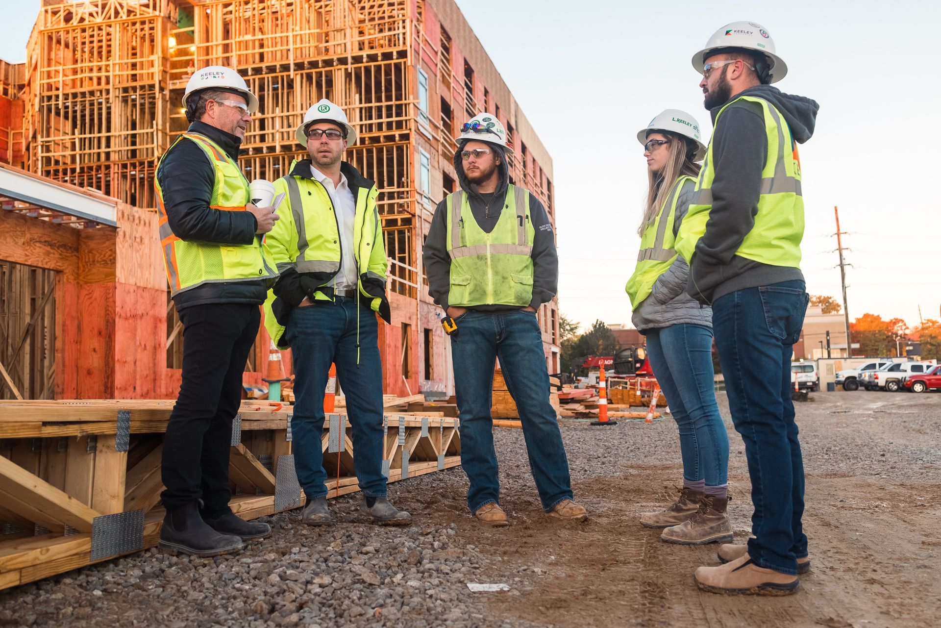 A group of construction workers are standing in front of a building under construction.