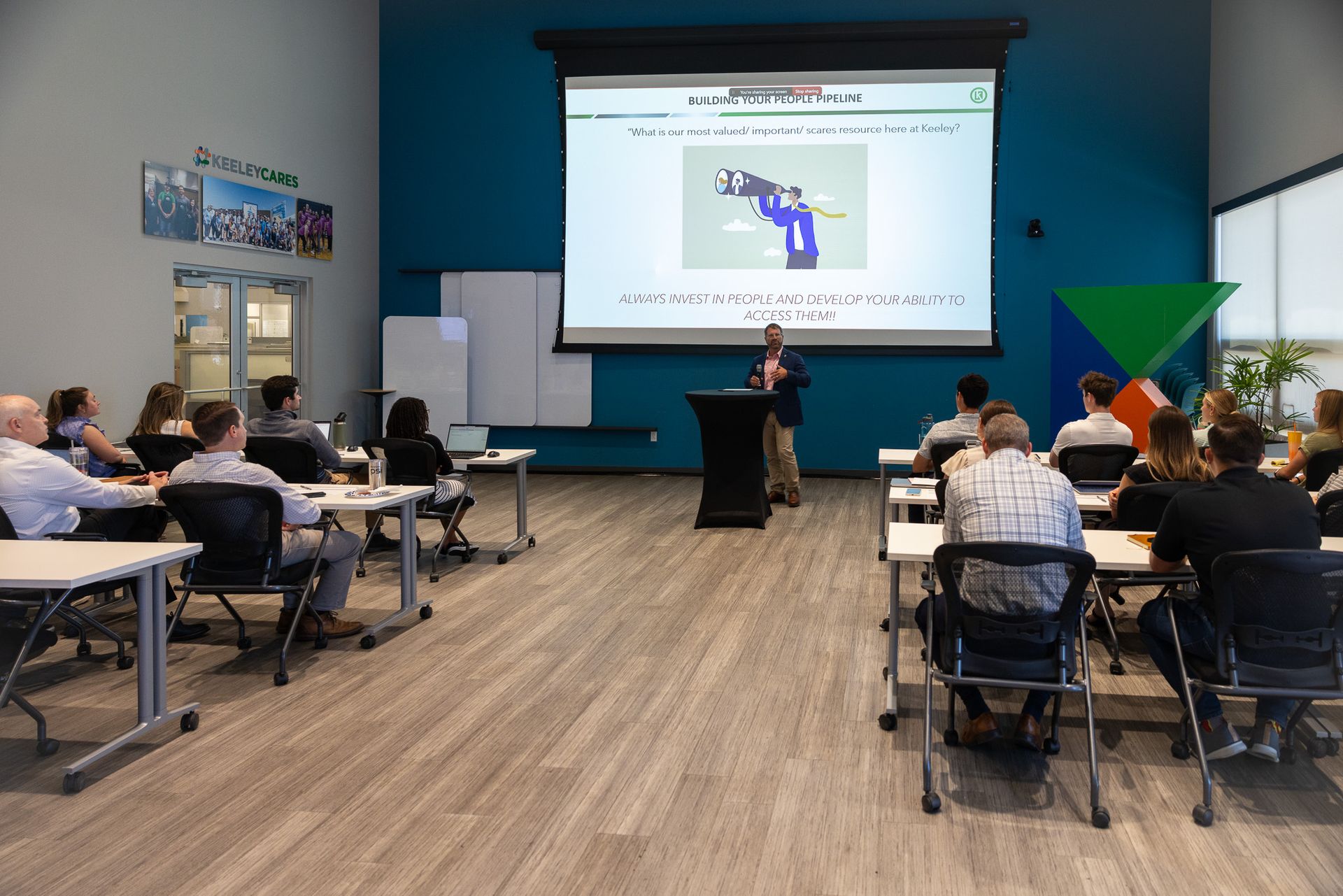 A woman is giving a presentation to a group of people in a classroom.