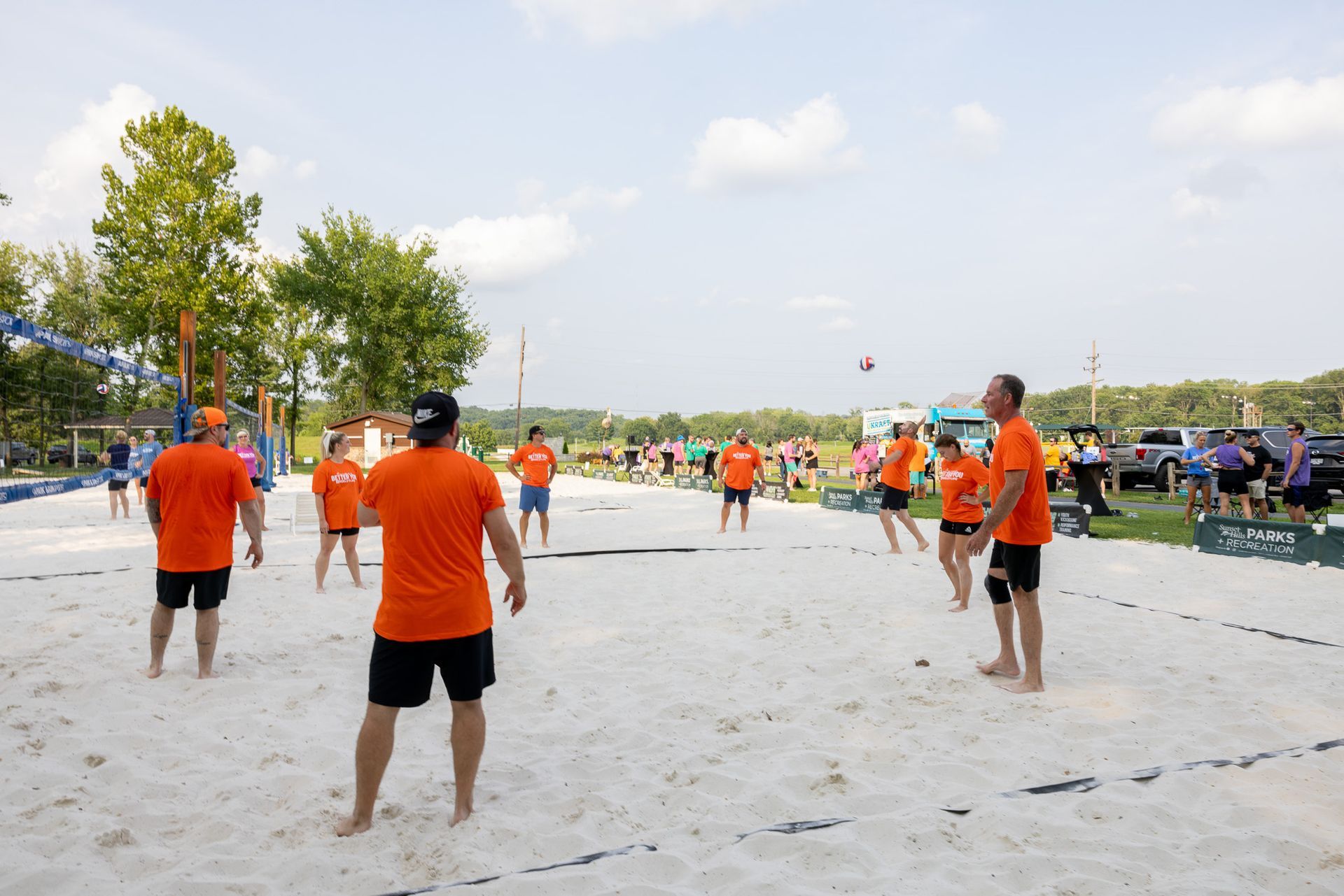 A group of people are playing volleyball on a sandy beach.