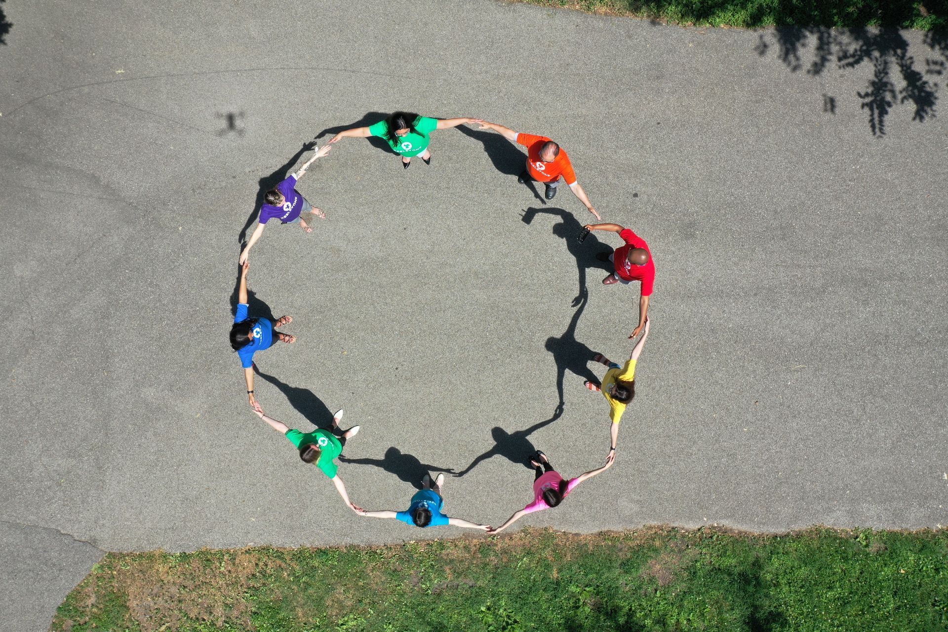 A group of people are standing in a circle holding hands.