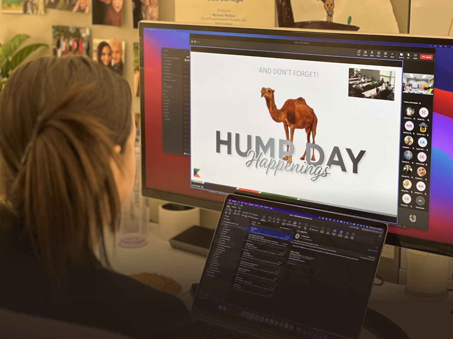 A woman is sitting in front of a computer screen with a camel on it.