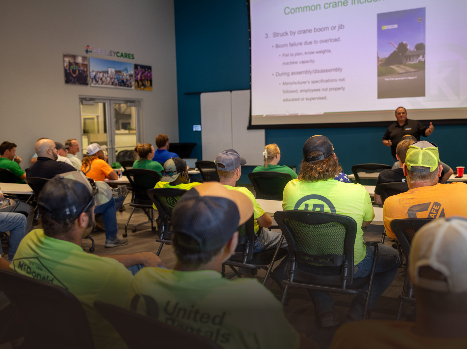 A group of people are sitting in a classroom watching a presentation.