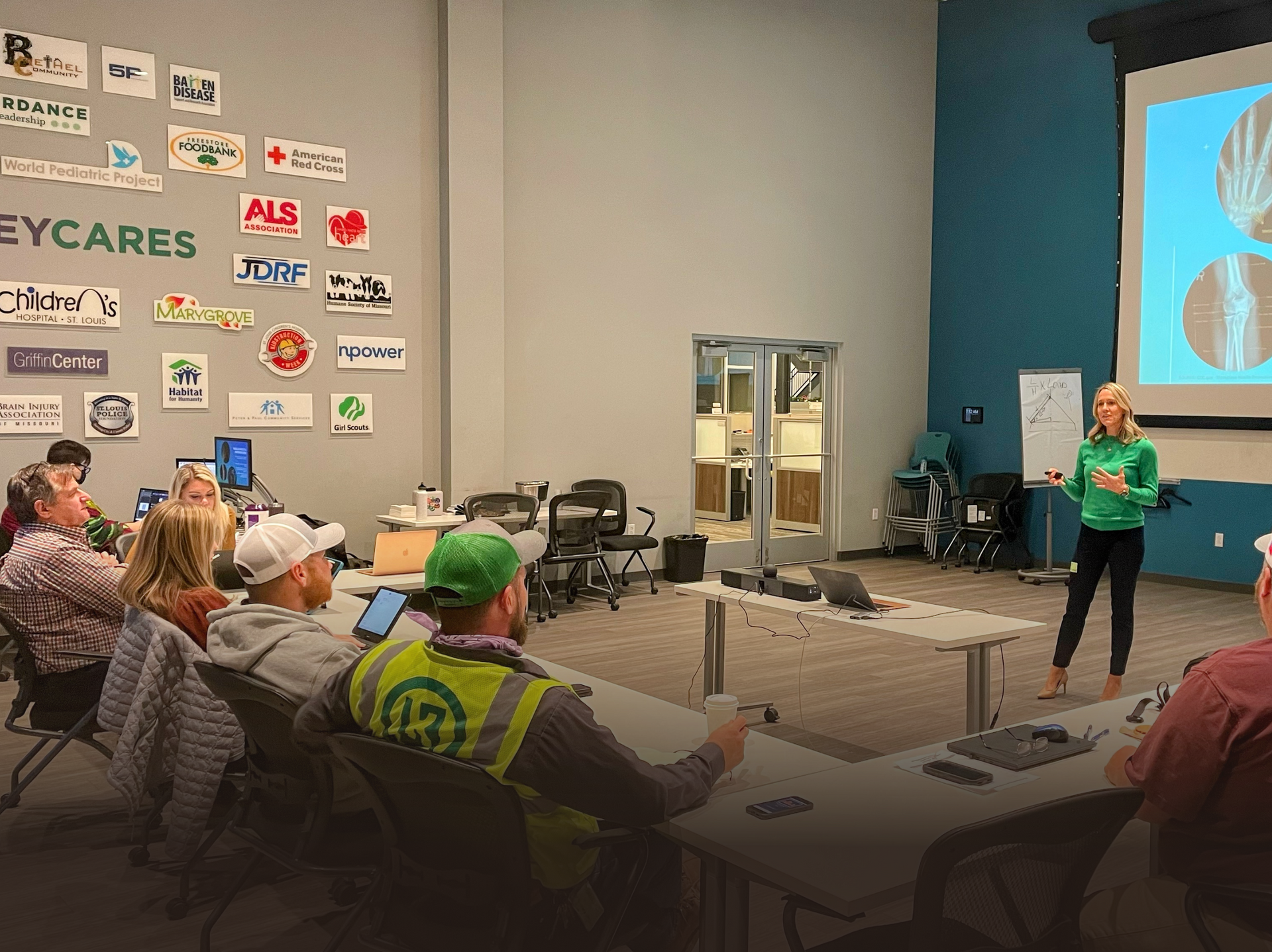 A woman is giving a presentation to a group of people in a room.