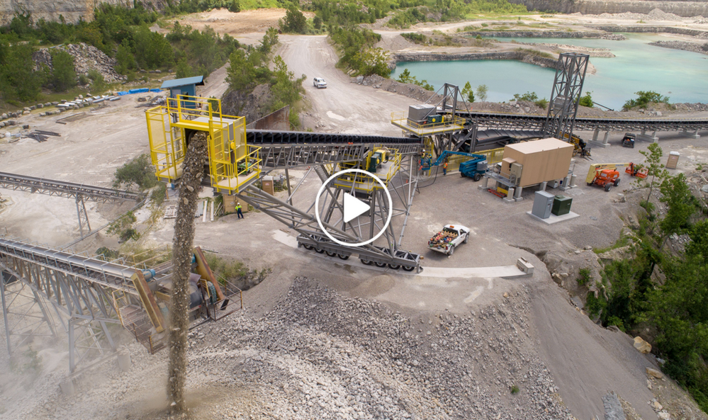 An aerial view of a large rock quarry with a large conveyor belt.