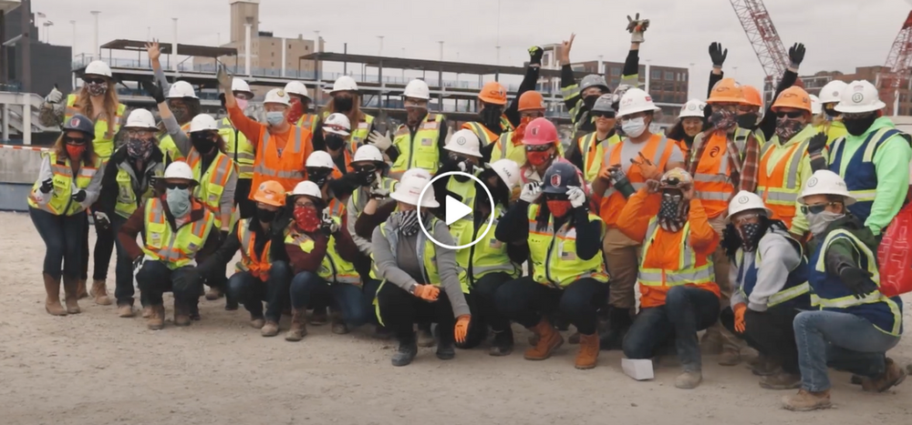 A large group of construction workers are posing for a picture.