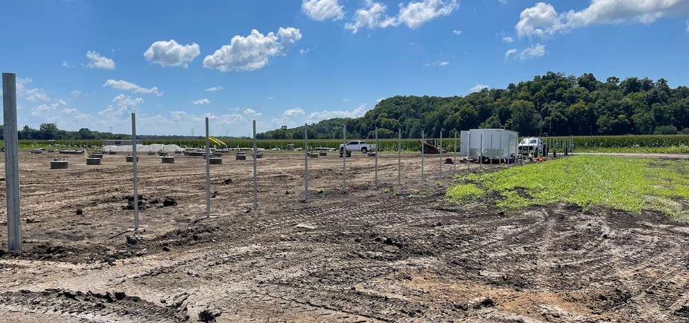 A large dirt field with a fence in the middle of it.