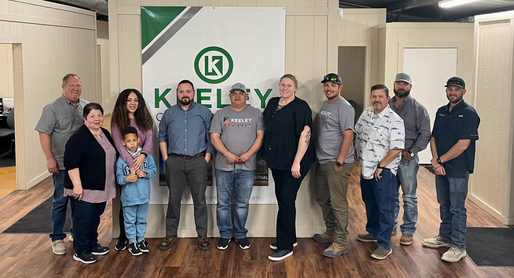 A group of people are posing for a picture in front of a sign.