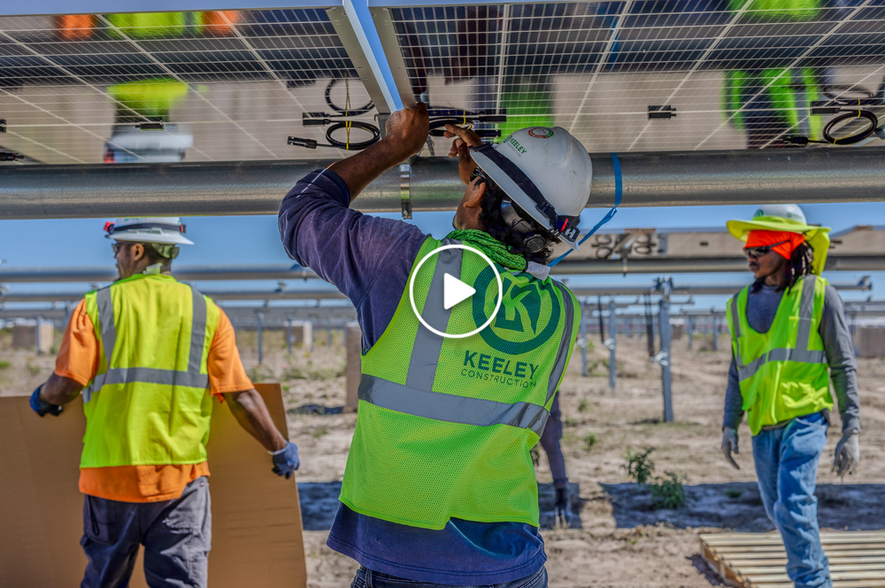 A group of construction workers are working on a solar panel.