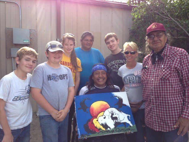 A group of people standing around a painting at Pine Ridge Reservation