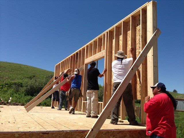 A group of people are working on a building at Pine Ridge Reservation