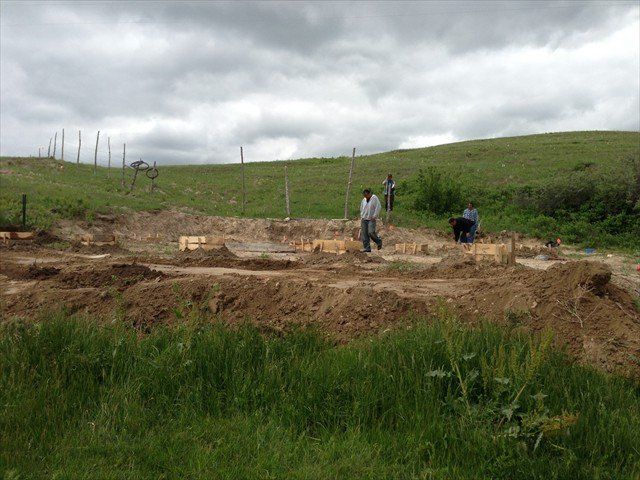 A group of people are working on a construction site in a field at Pine Ridge Reservation