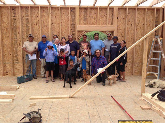 A group of people posing for a picture with their dogs at Pine Ridge Reservation