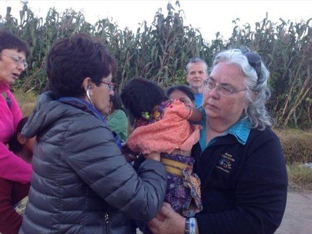 WHILE VISITING A MAYAN COMMUNITY IN GUATEMALA, WE NOTICED A CHILD THAT WAS SICK. DR. KATHIE NELSON LISTENING TO THE CHILD'S LUNGS NEXT TO THE CORN FIELD. MISSION OF LOVE HAS NO BARRIERS WHEN AIDING IN THE LIFE OF A CHILD IN NEED.