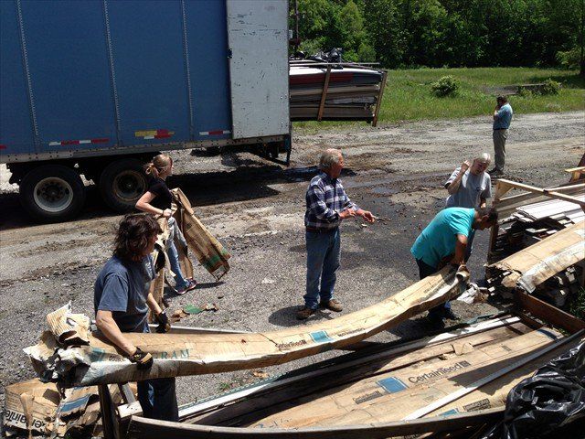 A group of people standing around a pile of cardboard boxes at Pine Ridge Reservation