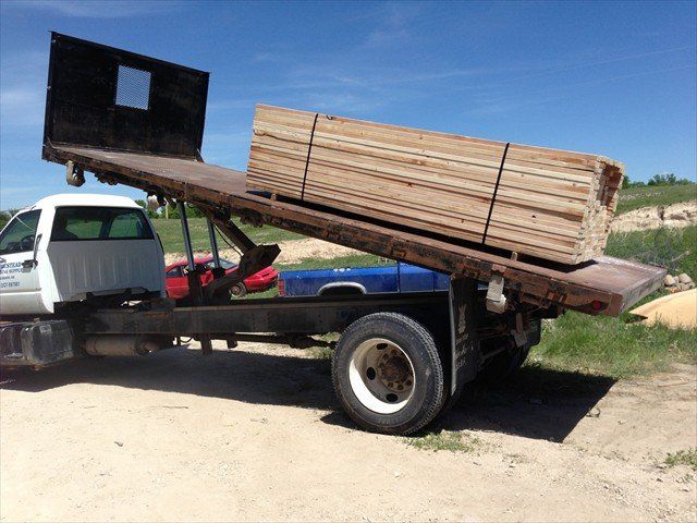 A truck with a stack of wood on the back of it at Pine Ridge Reservation