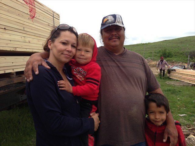 A family posing for a picture in front of a truck at Pine Ridge Reservation