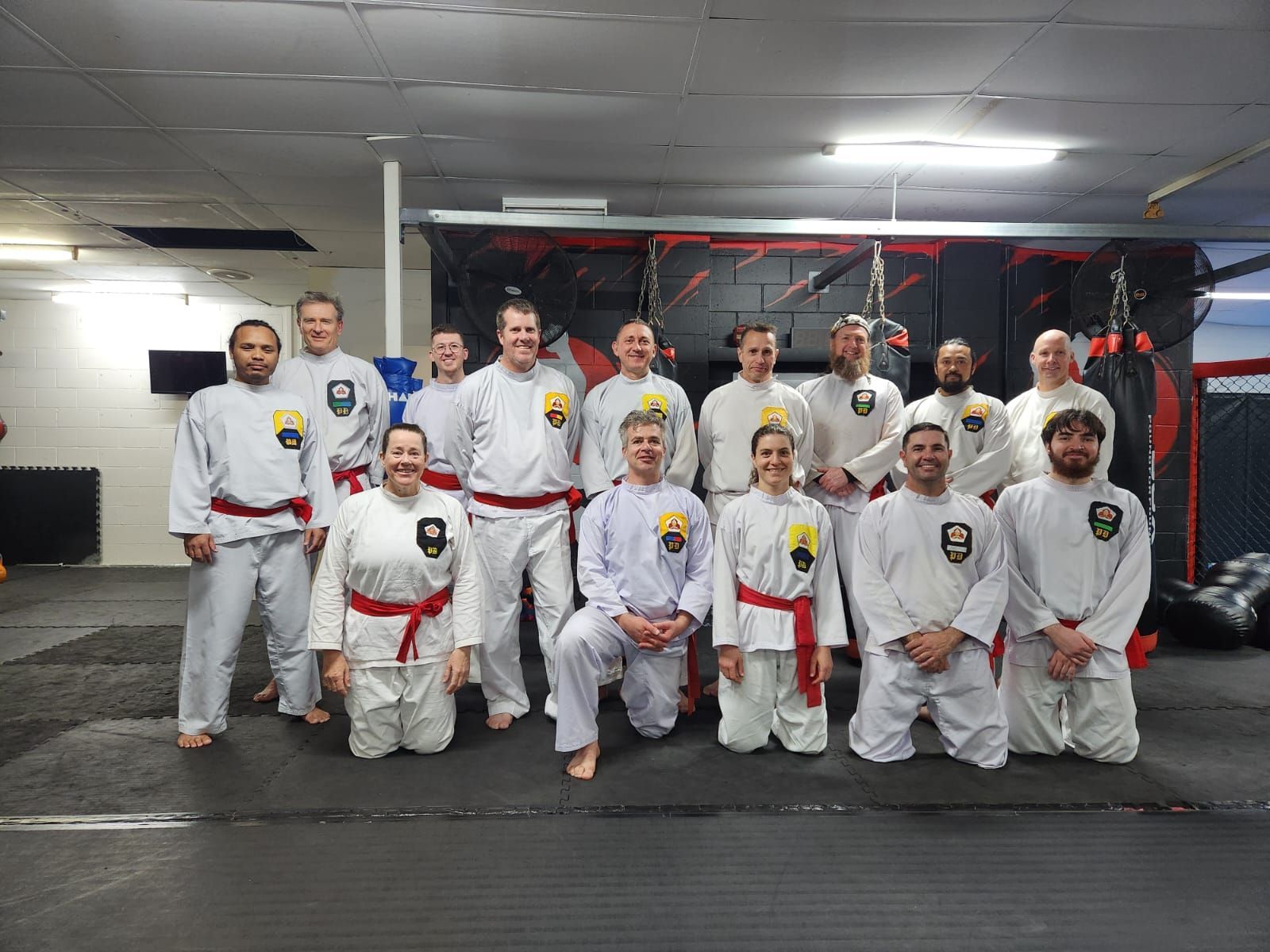 A group of people are posing for a picture in a gym.