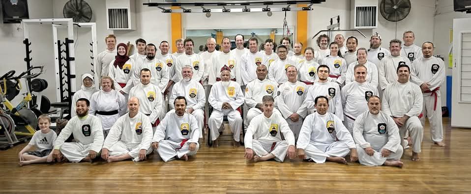 A large group of people are posing for a picture in a gym.