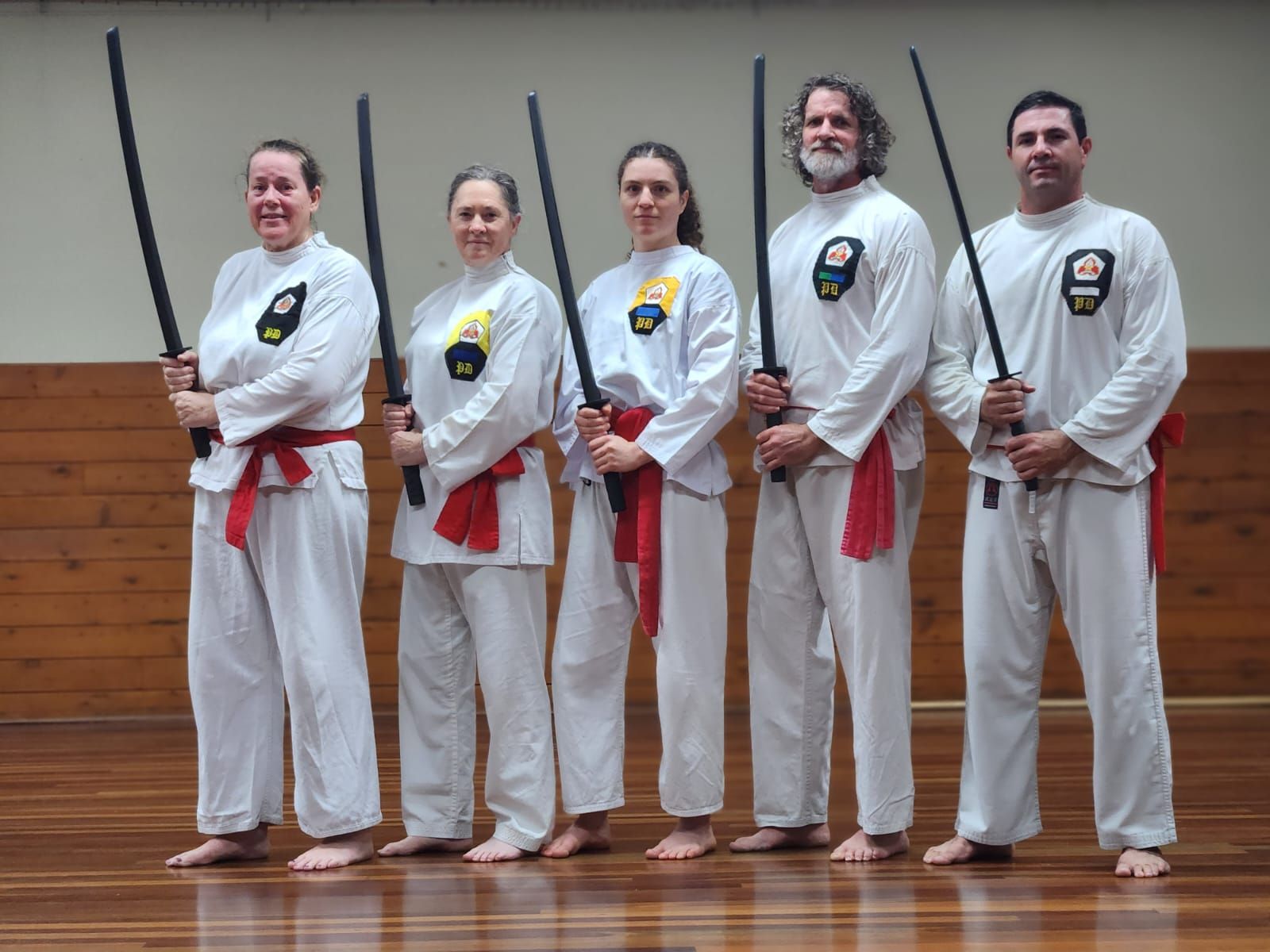 A group of people standing next to each other holding swords.