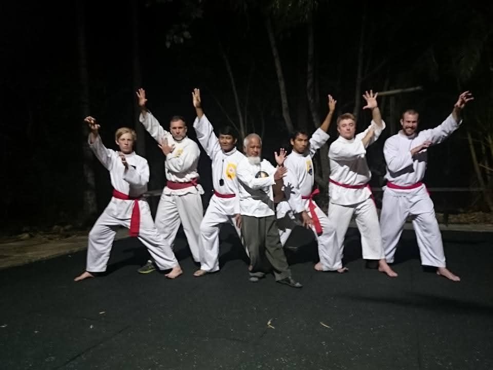 A group of people in karate uniforms are posing for a picture