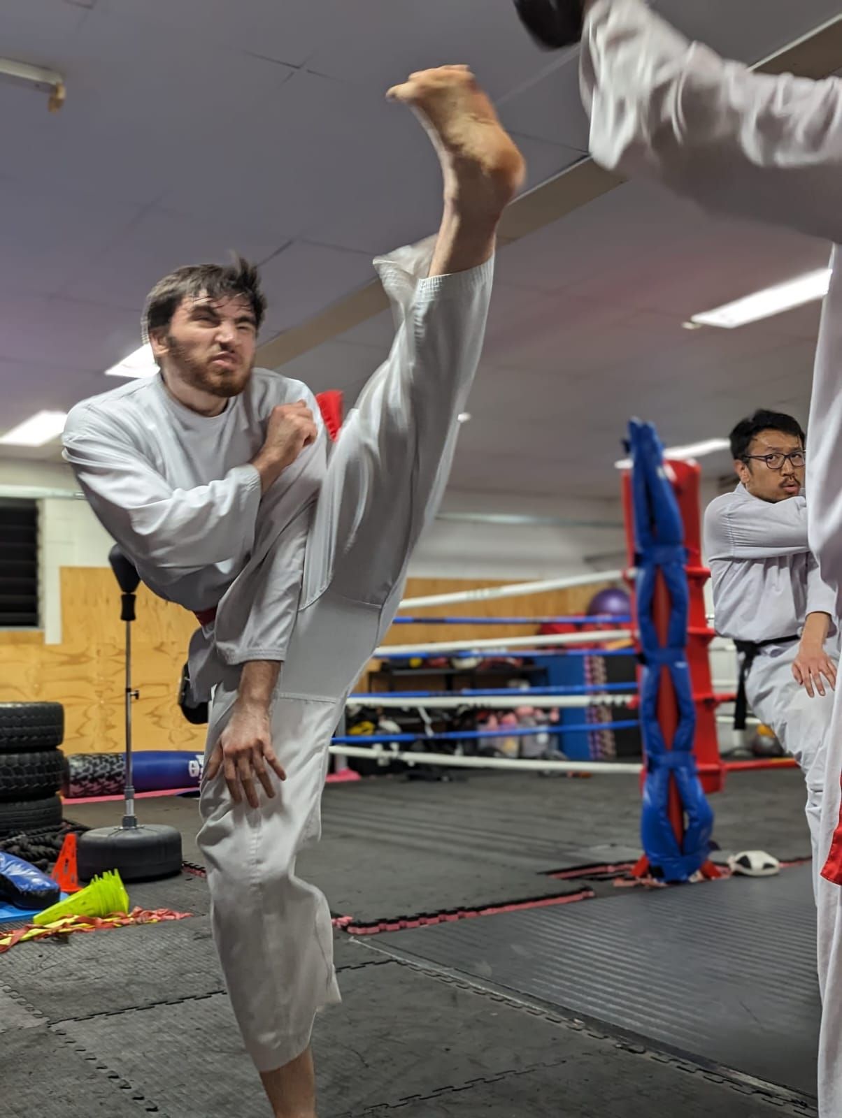 A man is doing a kick in a karate ring