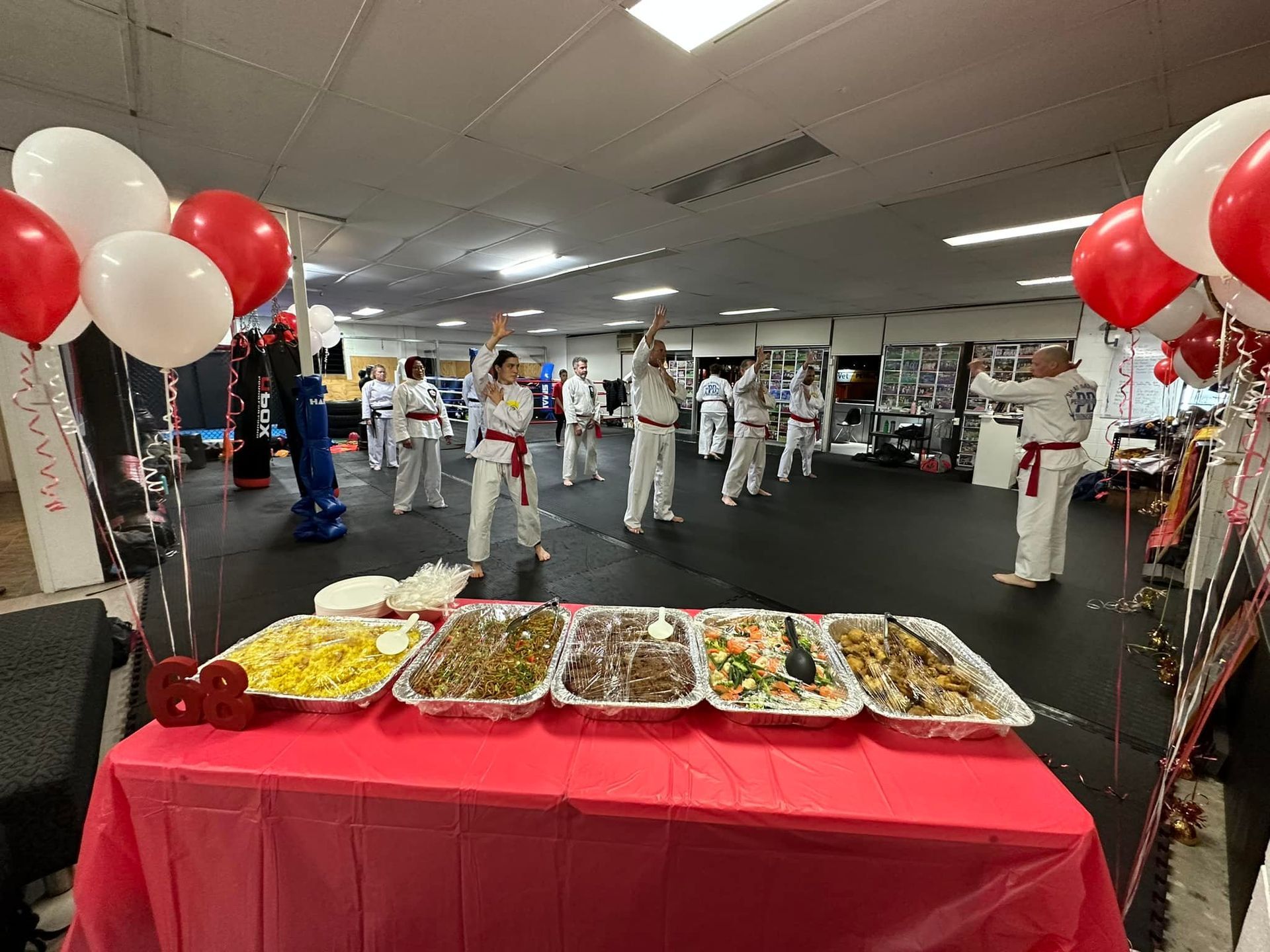 A group of people are practicing martial arts in a gym.