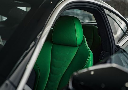 A close up of a green seat in a car.