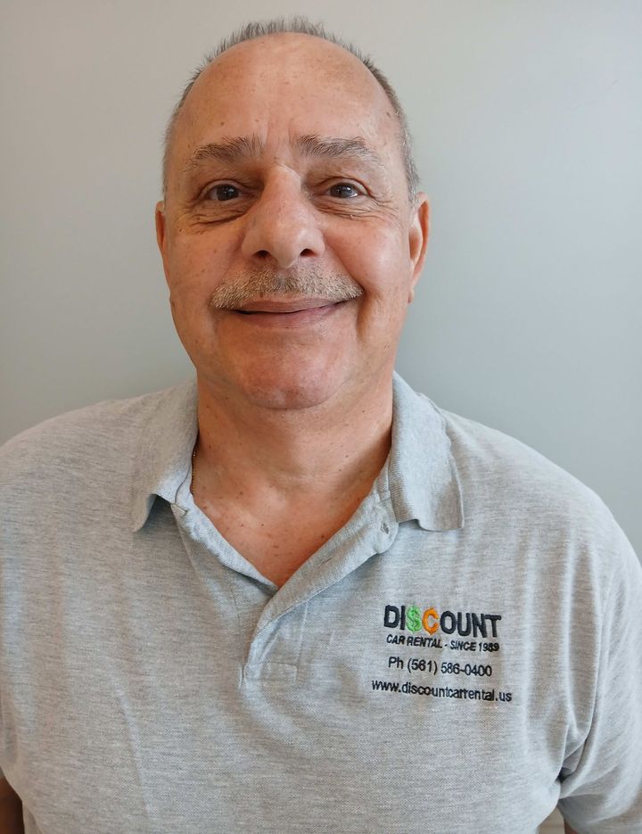 A man wearing a discount shirt is smiling for the camera