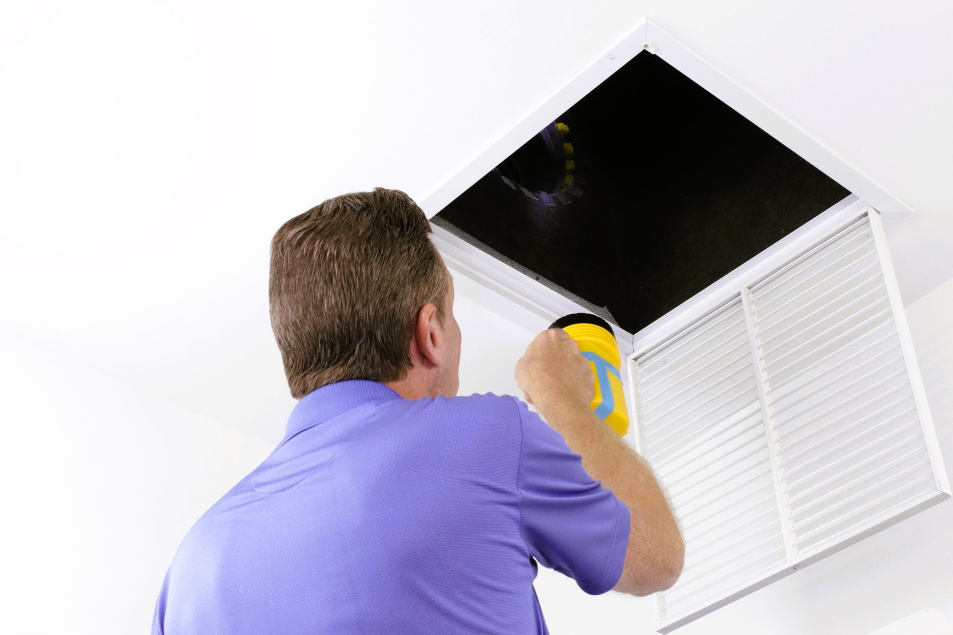 homeowner inspecting a home's duct work for buildup and debris.