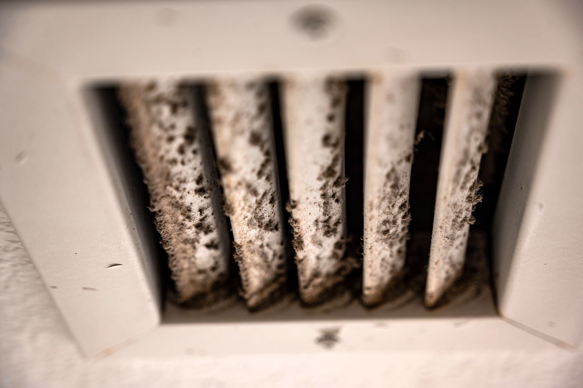 Dusty air vent with clogged slats, showing poor indoor air quality