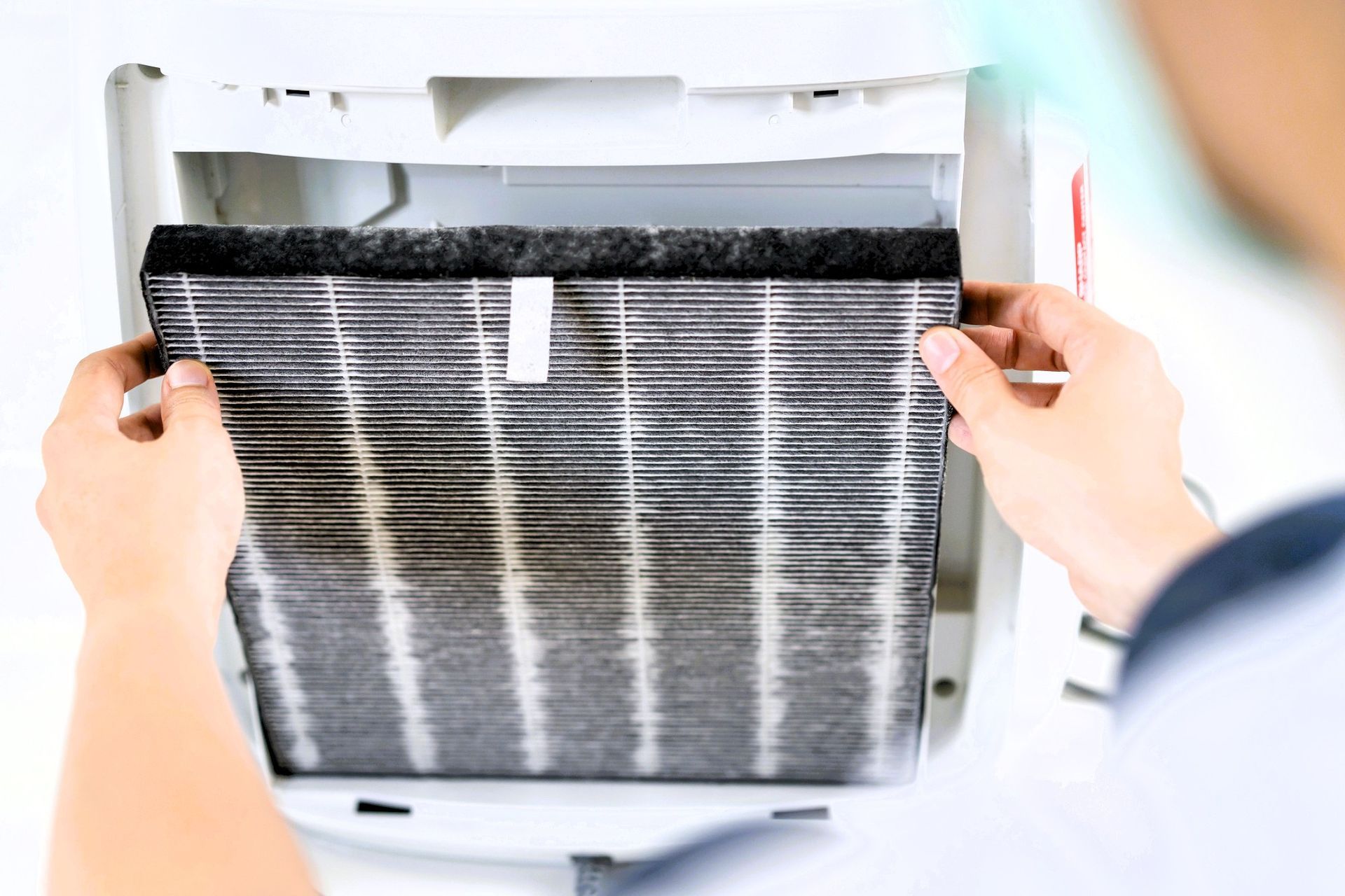 Technician replacing dirty HVAC air filter to improve indoor air quality