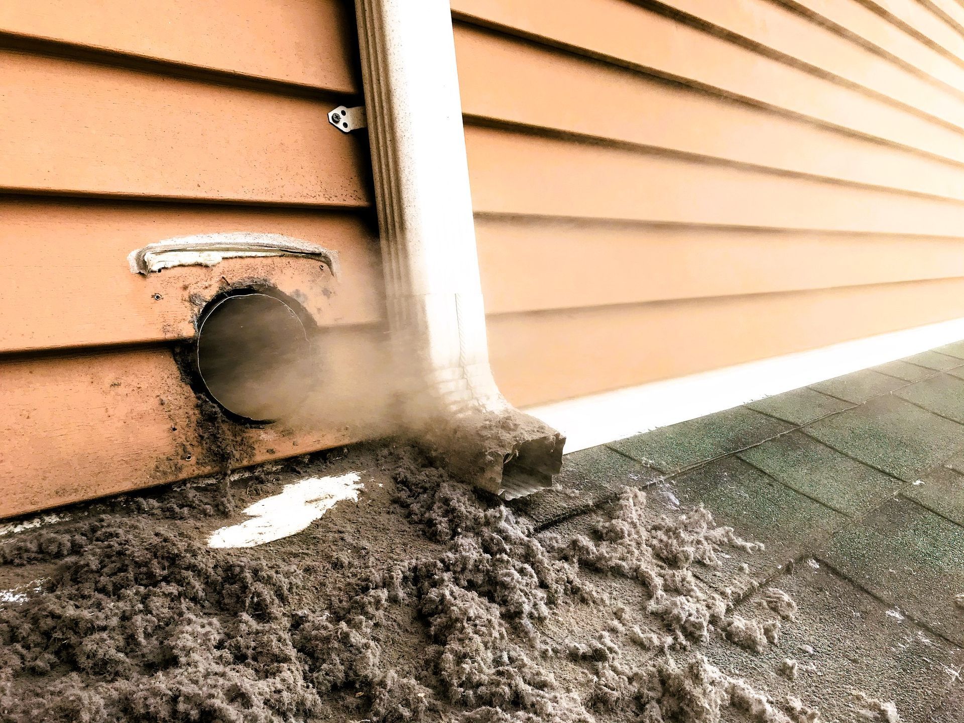 Lint collected from dryer machine is blowing out from vent