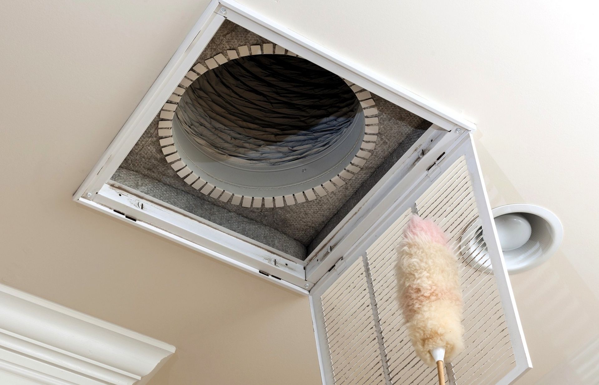 Open vent with duster showing dusty ducts to maintain clean ducts year-round