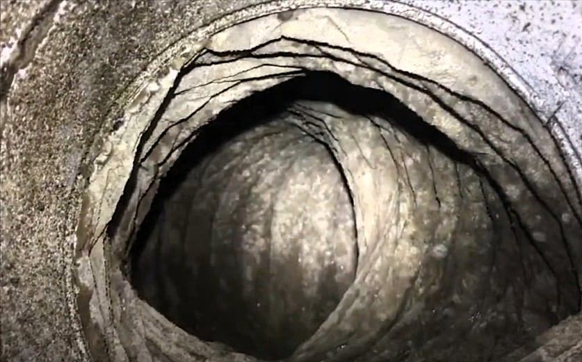 Close-up view of a moldy air duct with buildup inside