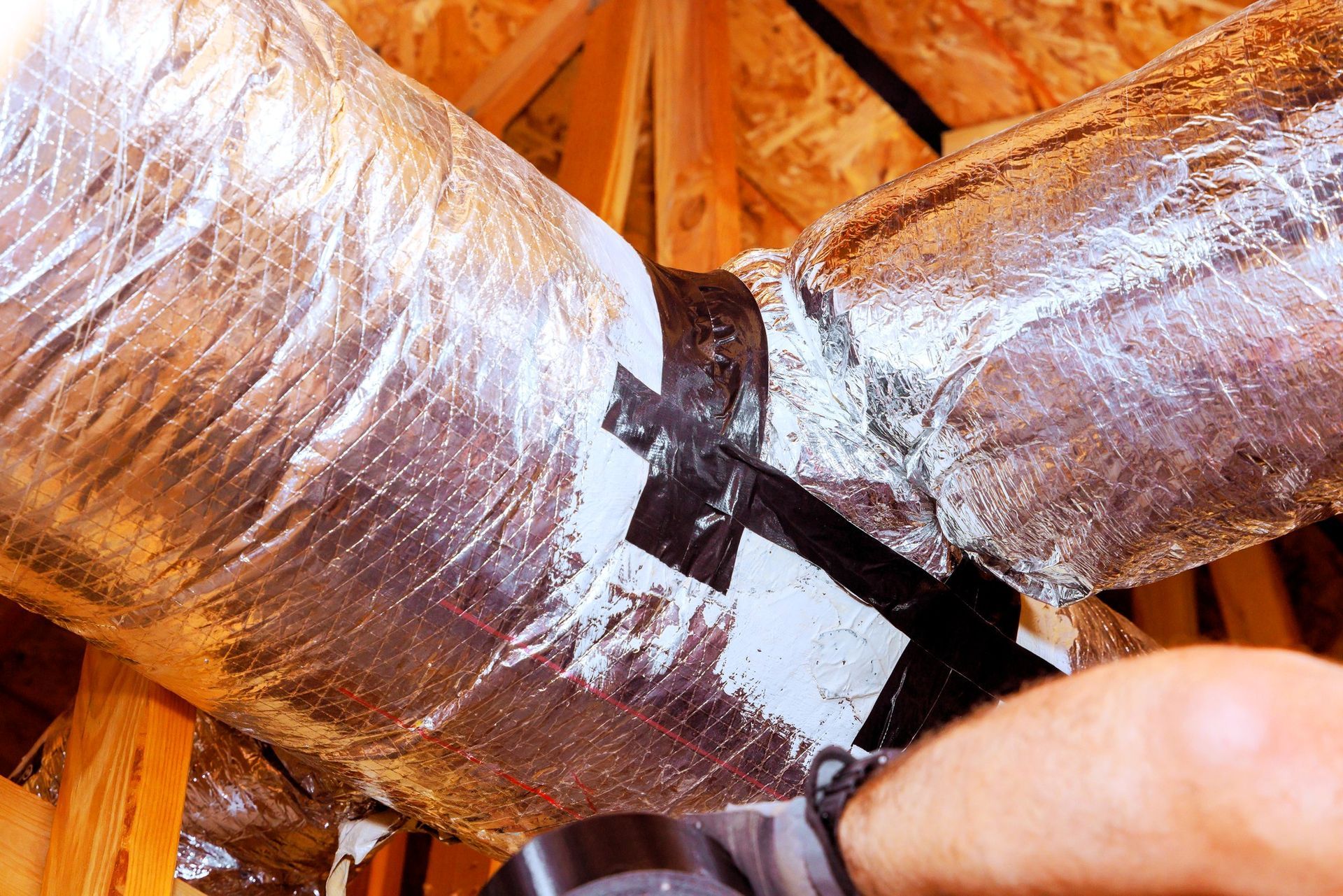 Professional duct sealing with foil insulation and tape to improve HVAC efficiency