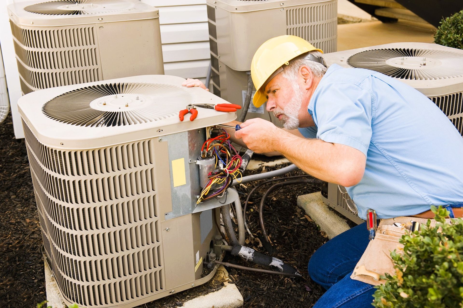 HVAC technician diagnosing outdoor AC unit by listening for sounds