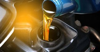 Pouring oil in engine of car | Eagle Transmission & Auto Repair