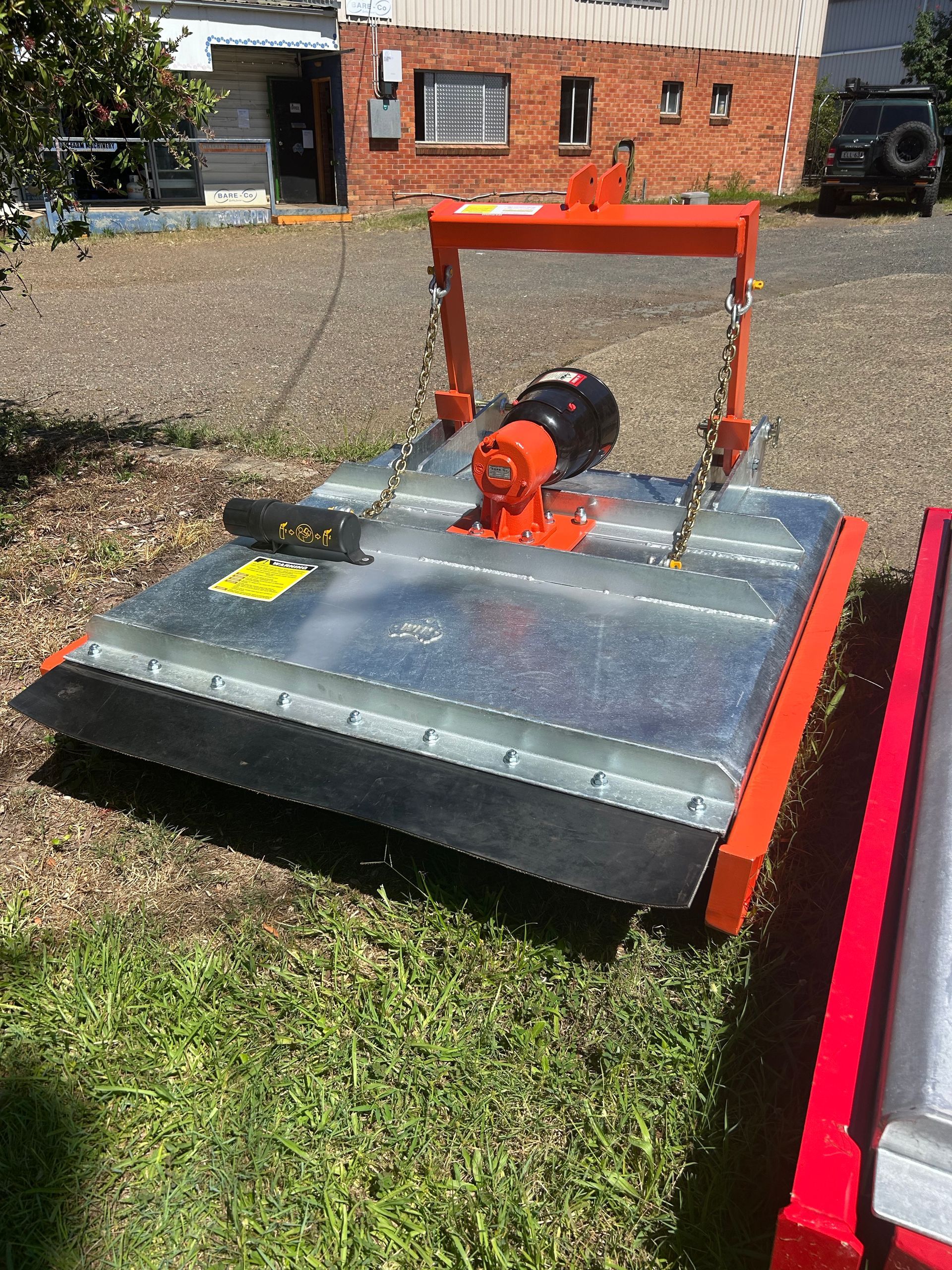 A Green and Silver Lawn Mower is Parked on the Side of the Road — Wingham Farm Machinery in Wingham, NSW