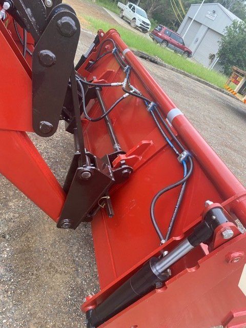 A Red Tractor is Parked on a Dirt Road  — Wingham Farm Machinery In Wingham, NSW
