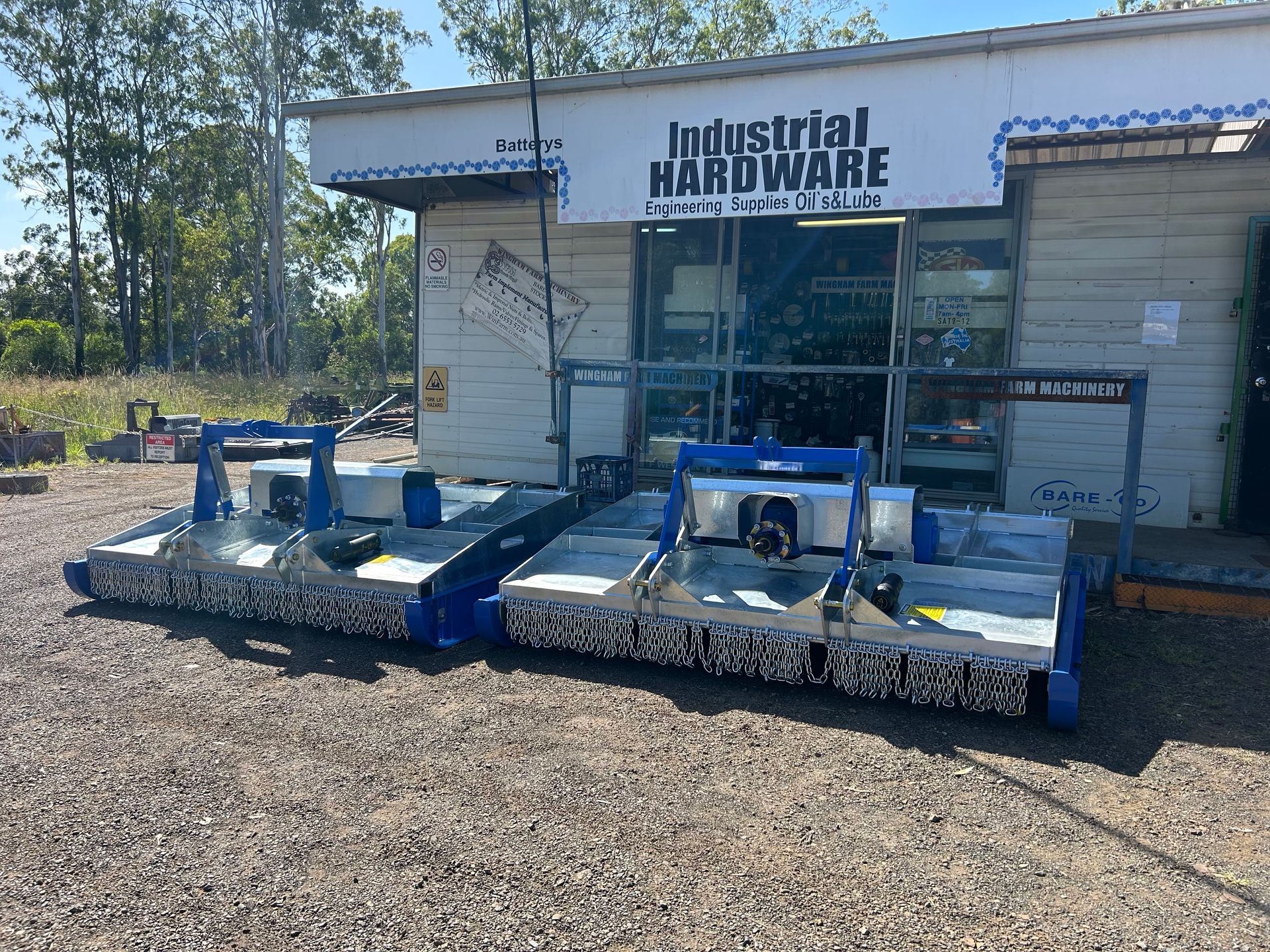 A Black Bucket With a Tractor Attached to It is Sitting in Front of a Building — Wingham Farm Machinery in Wingham, NSW