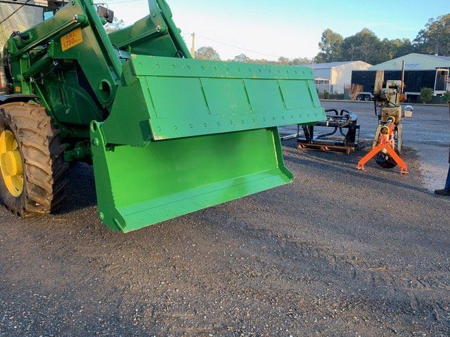 A John Deere Tractor is Parked in Front of a Building — Wingham Farm Machinery In Wingham, NSW
