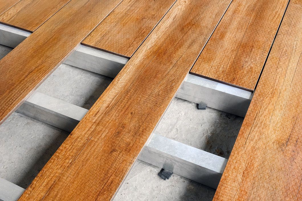 A close up of a wooden floor with a concrete foundation.